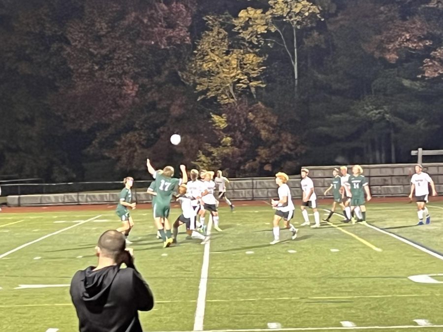 Oakmont pushes the ball through the air. Mr. Dufour in front taking yearbook photos.