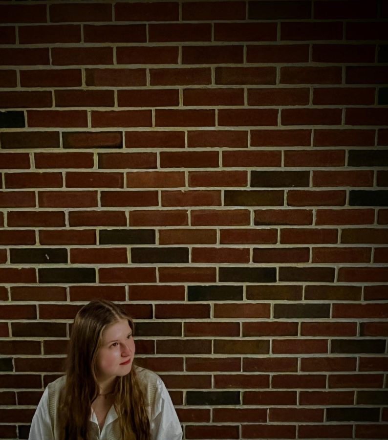 Isabel Wandless took a photo of a student standing around a brick wall. 