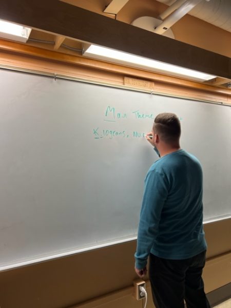 Mr. Alexander Dewhurst, an English teacher, writes on his board