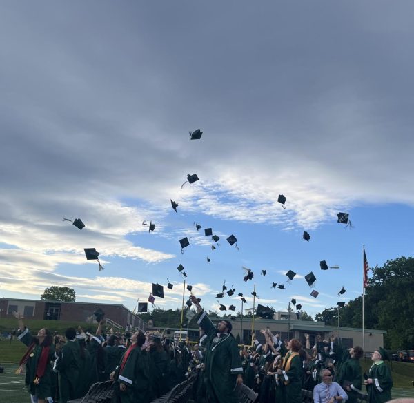 Seniors throwing their caps into the air celebrating graduation!