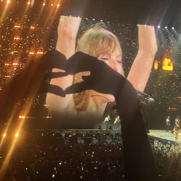 Taylor Swift gives heart to fans during the song "Fearless"