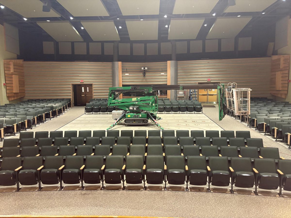 The cherry picker in the auditorium maintenance is using to repair the lighting.