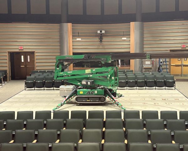 The cherry picker in the auditorium maintenance is using to repair the lighting.
