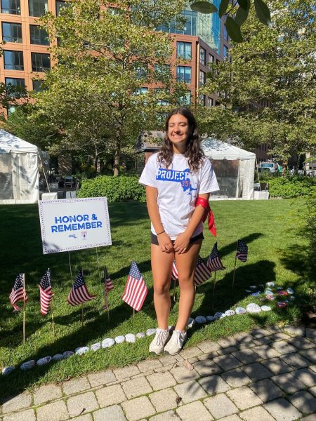Oakmont Junior Emma Goodwin stands with Project 351's 9/11 Tribute Service set up behind her.