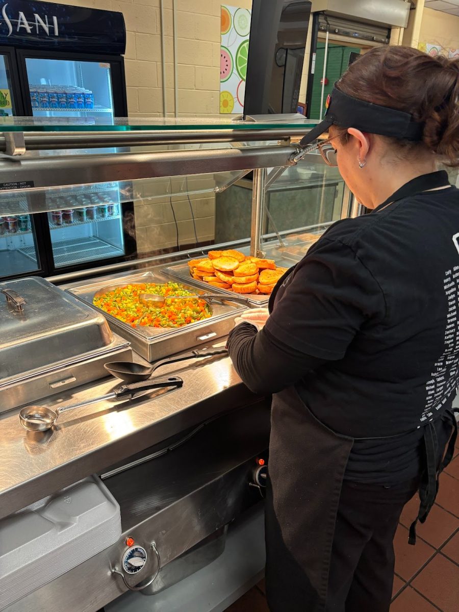 Oakmont cafeteria worker preparing the pasta line for first lunch. 