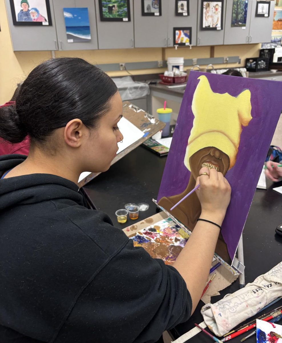 Senior Natasha Hood adding the final touches to her painting.