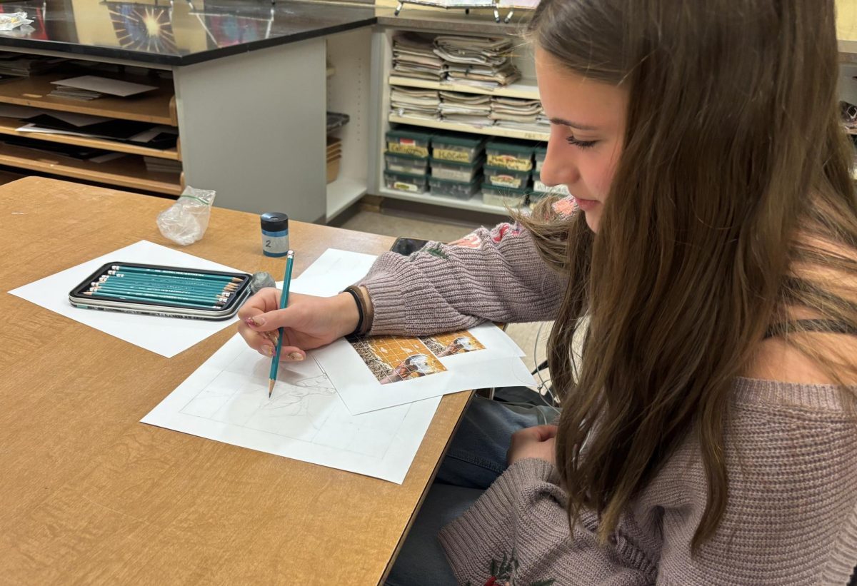 Junior Sydney Taylor sketching out her final draft with pencil.