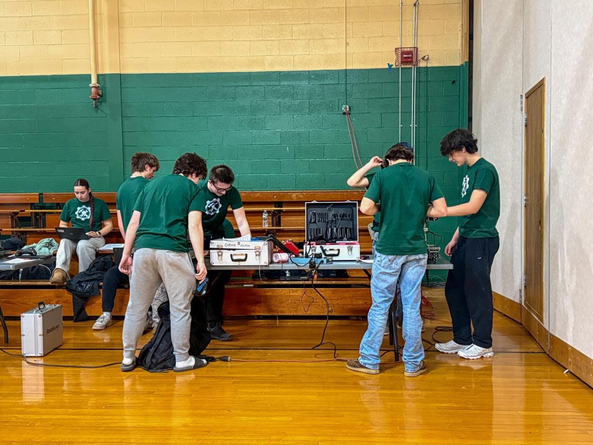 Two of the seven Oakmont Regional High School robotics teams fine-tuning and preparing their robot for the next match.