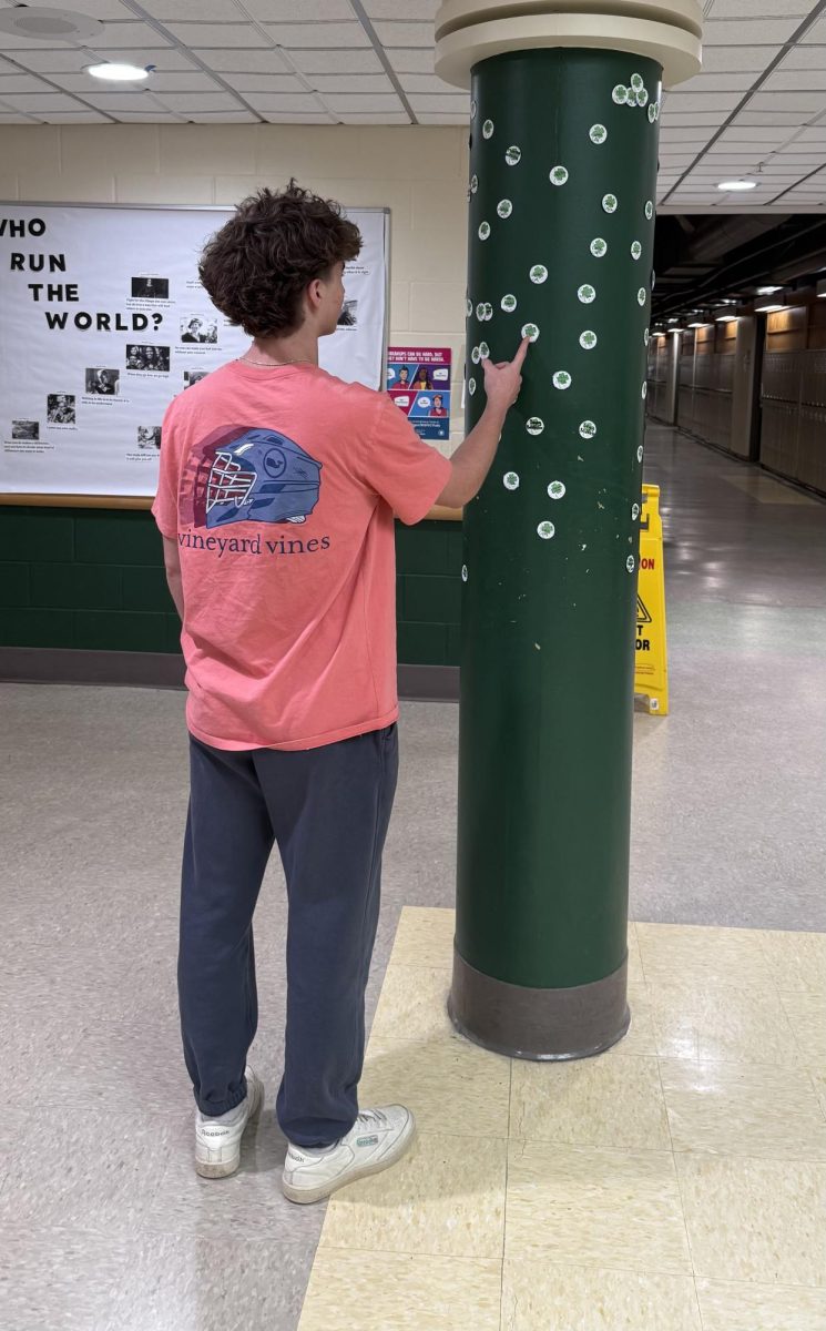 Oakmont sophomore Mikey Belcher looking for his name on the StuCo clovers down at four corners for St. Patrick's Day