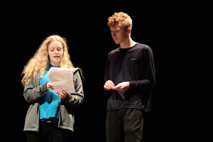 Group reading off their script during their March Madness Performance.