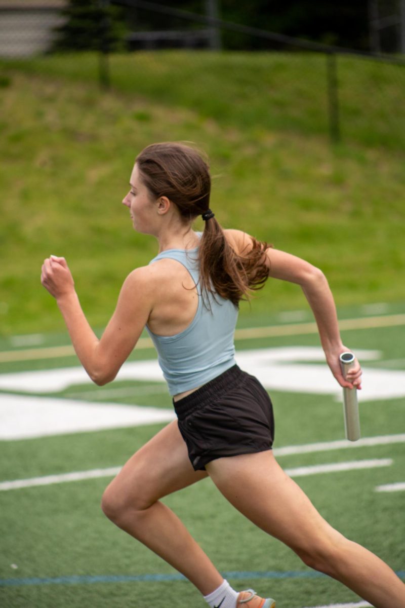 Junior Grace Alatalo in the final stretch of her lap heading towards the hand-off zone.