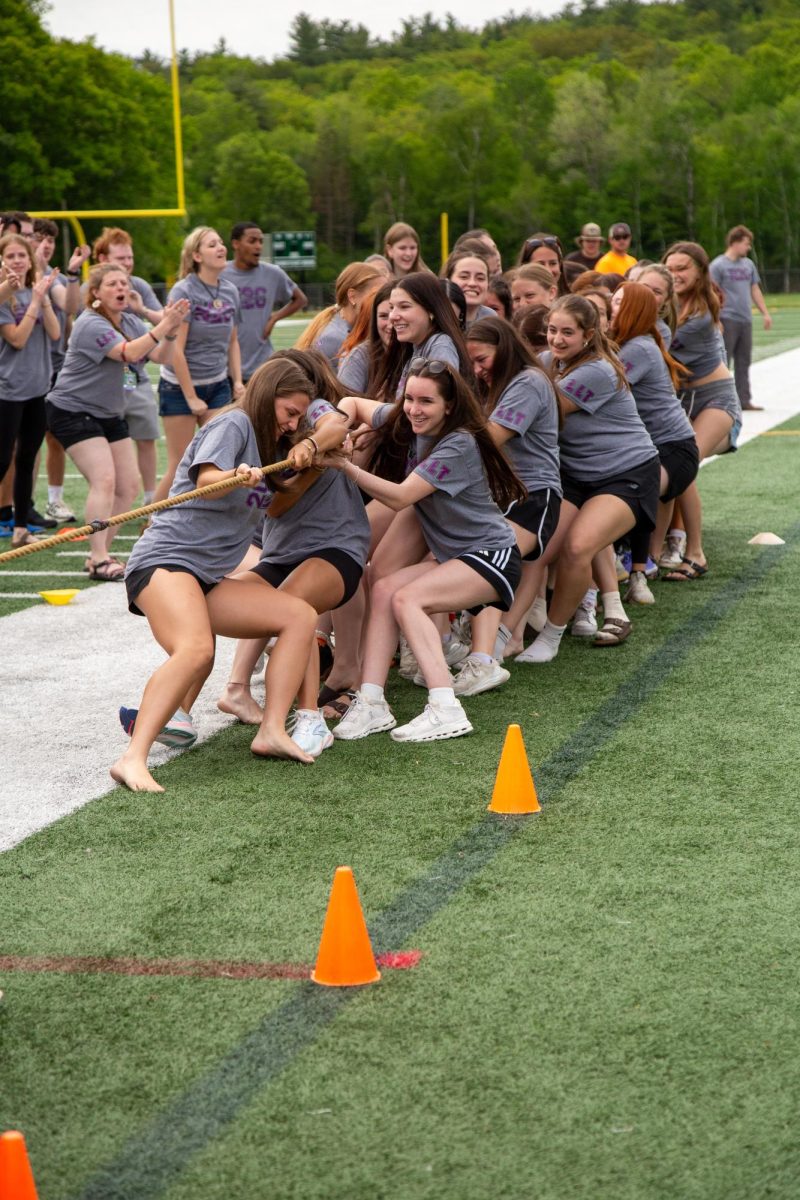 Senior girls in an intense tug-of-war battle against junior girls.