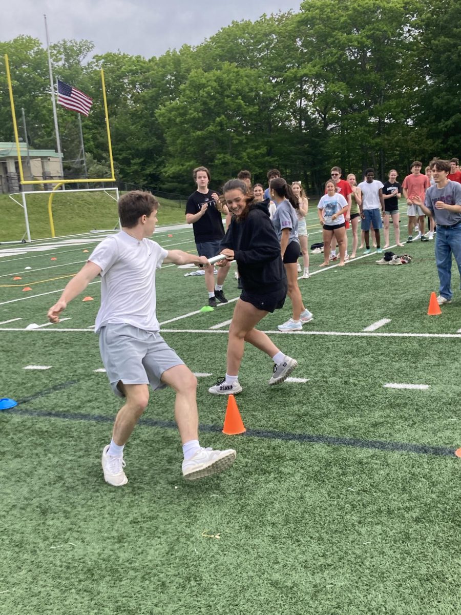 A baton being passed from one junior to another in the relay