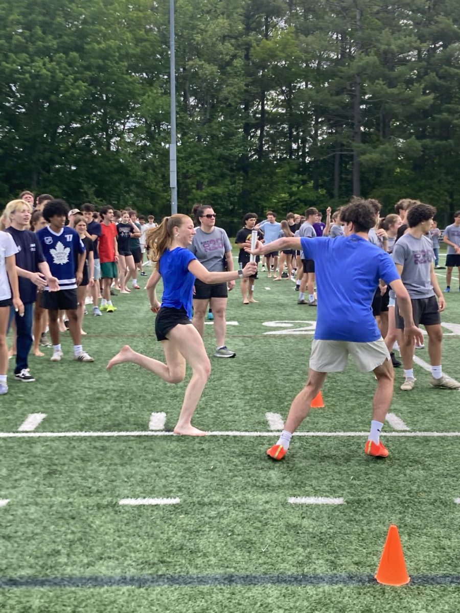 The baton being passed from one junior to another during relay.